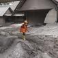Seorang tim penyelamat berjalan di daerah yang dilanda letusan Gunung Semeru di Kabupaten Lumajang, Provinsi Jawa Timur, Minggu (5/12/2021). BNPB menyatakan, korban meninggal akibat Gunung Semeru meletus mencapai 13 orang. Sementara 41 orang yang mengalami luka-luka. (AP Photo/Trisnadi)