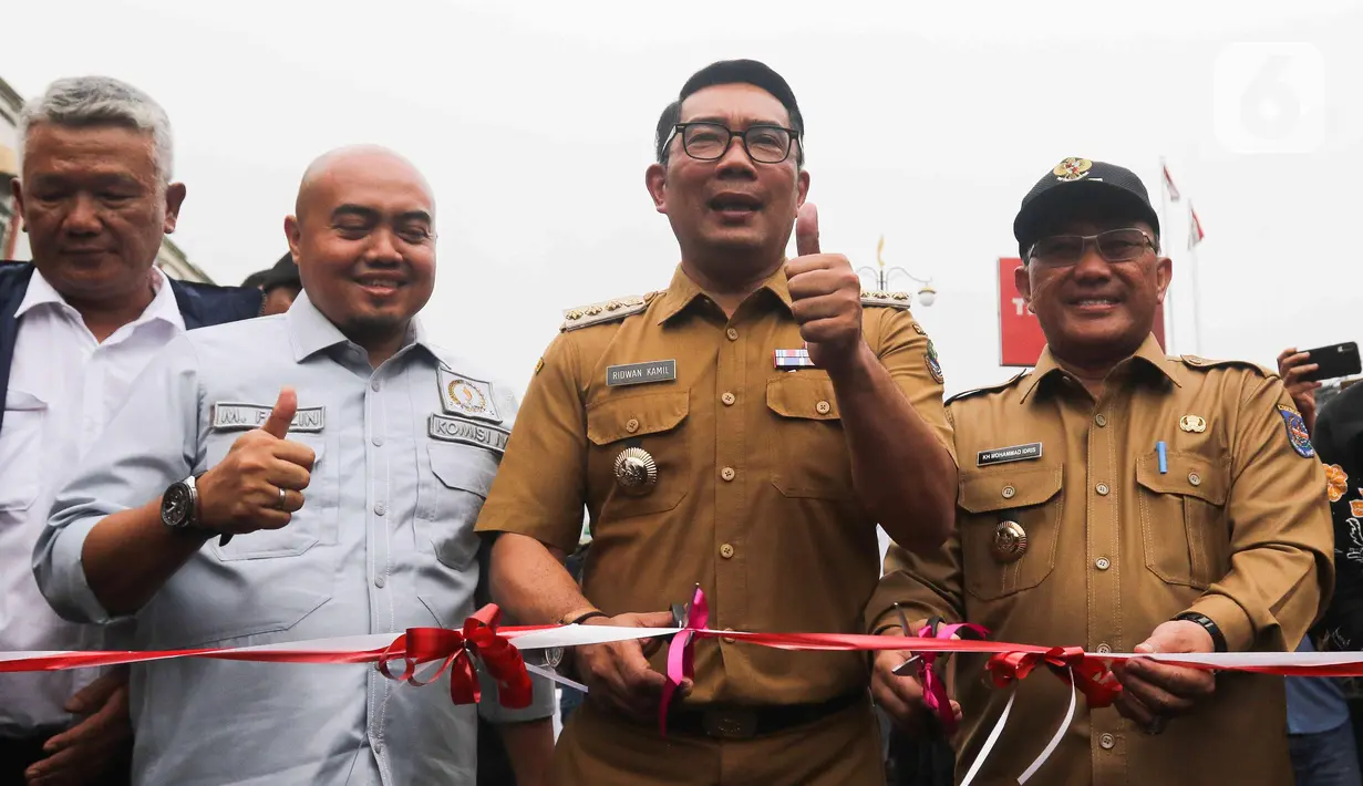 Gubernur Jawa Barat Ridwan Kamil bersama Walikota Depok Mohammad Idris bersiap mengunting pita untuk meresmikan Jalan Underpass Dewi Sartika di Depok, Jawa Barat, Selasa (17/1/2023). Diketahui, proyek pembangunan underpass Jalan Dewi Sartika ini menelan biaya sebesar Rp180 miliar. (Liputan6.com/Herman Zakharia)