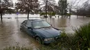 Sebuah mobil terendam dalam air banjir di Camden di pinggiran Sydney, Australia, Senin (4/7/2022). Lebih dari 30.000 penduduk Sydney dan sekitarnya telah diberitahu untuk mengungsi atau bersiap untuk meninggalkan rumah mereka pada hari Senin di tengah kondisi cuaca yang buruk. (AP Photo/Mark Baker)