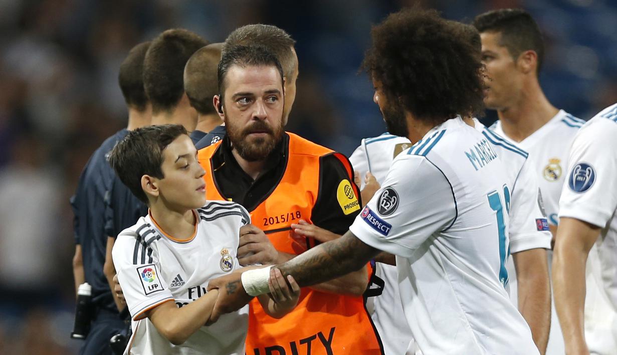 Fans cilik masuk lapangan saat Real madrid melawan APOEL Nicosia pada laga grup H Liga Champions di Santiago Bernabeu stadium, Madrid, (13/9/2017). Real Madrid Menang 3-0. (AP/Francisco Seco)