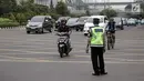 Petugas polisi berjaga saat pengendara sepeda motor melintasi Jalan MH Thamrin-Medan Merdeka Barat, Jakarta, Kamis (11/1). Mahkamah Agung (MA) membatalkan Pergub DKI tentang larangan sepeda motor melintas di jalan tersebut. (Liputan6.com/Arya Manggala)