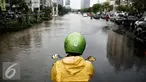 Pengendara motor berhenti sebelum melintasi genangan air di kawasan Kelapa Gading, Jakarta, Jumat (26/2/2016). Hujan deras yang mengguyur Ibukota membuat beberapa ruas jalanan tersendat. (Liputan6.com/Faizal Fanani)