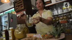 Penjual menyiapkan olahan jamu pesanan pembeli di warung Jamu Bukti Mentjos, Jakarta, Rabu (20/12/2023). (merdeka.com/Imam Buhori)