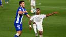 Penyerang Real Madrid, Rodrygo, berebut bola dengan bek Alaves, Martin Aguirregabiria, pada laga lanjutan La Liga pekan ke-35 di Stadion Alfredo di Stefano, Sabtu (11/7/2020) dini hari WIB. Real Madrid menang 2-0 atas Alaves. (AFP/Gabriel Bouys)