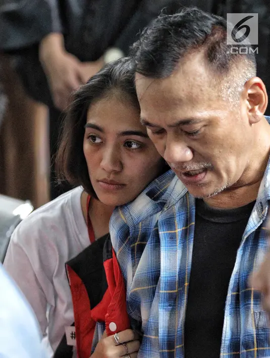Aktor Tio Pakusadewo merangkul anak perempuannya, Risa saat menunggu sidang  kasus penyalahgunaan narkoba di Pengadilan Negeri Jakarta Selatan, Kamis (28/6). Sidang beragenda pembacaan pledoi oleh Tio. (Liputan6.com/Faizal Fanani)