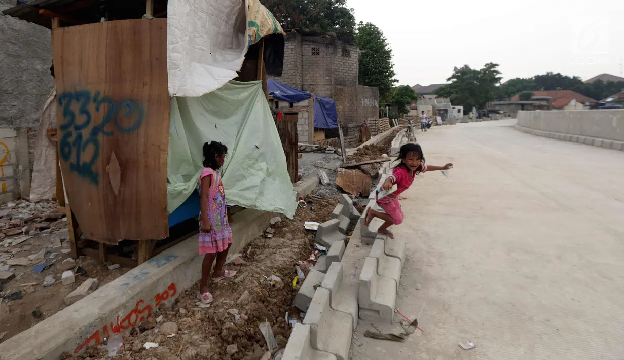 Anak-anak bermain didekat proyek normalisasi sungai Ciliwung, Jakarta, Minggu (5/11). Ketua BBWSCC, Teuku Iskandar mengatakan pengerjaan normalisasi sungai Ciliwung sudah selesai 11 kilometer atau sekitar 61 persen. (Liputan6.com/Johan Tallo)