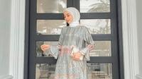 Inspirasi outfit kondangan yang elegan, padukan tunik satin dengan kulot dan hijab warna putih. Tak lupa, tambahkan pula clutch warna senada (Instagram/liza.rosalita).