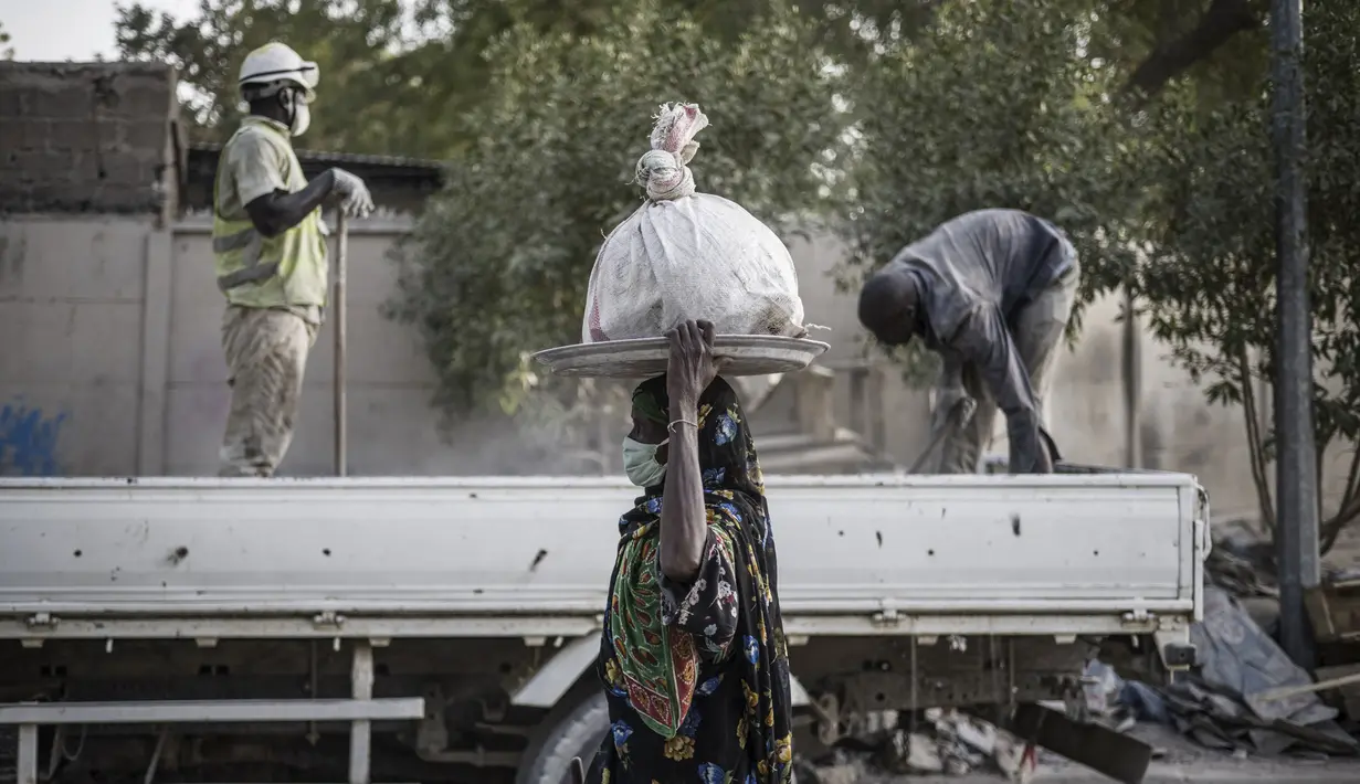 Sebuah truk menurunkan batu dan bahan konstruksi sisa lainnya yang digunakan oleh para wanita untuk dihancurkan menjadi kerikil dan dijual sebagai pelengkap beton murah di sebuah lokasi dekat Cite International des Affaires, N'Djamena, Chad, 12 April 2021. (MARCO LONGARI/AFP)