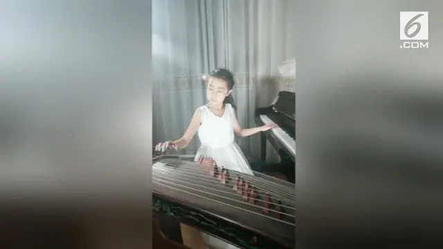 Seorang gadis berusia 9 tahun piawai bermain 2 alat musik sekaligus. Ia memainkan piano dan kecapi China  secara bersamaan.