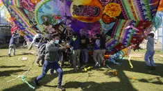 Warga membantu mengangkat layang-layang raksasa untuk ditampilkan pada Hari Semua Orang Kudus sebagai bagian dari perayaan Hari Kematian di Santiago Sacatepequez, Guatemala, 1 November 2021. Perayaan digelar dengan sejumlah pembatasan untuk mengekang penyebaran COVID-19. (AP Photo/Moises Castillo)