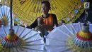 Perajin menyelesaikan pembuatan payung kertas di Desa Tanjung, Kecamatan Juwiring, Klaten, Kamis (11/10). Mereka meneruskan kerajinan payung hias yang merupakan warisan seni pada era 1800-an dari leluhurnya. (Liputan6.com/Gholib)