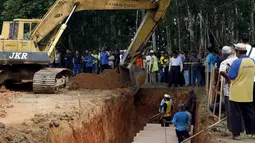 Alat berat disiagakan di sekitar lokasi pemakaman massal jenazah yang di duga etnis Rohingya di Alor Setar, Malaysia, Senin (22/6/2015).  21 dari 106 jenazah tak dikenal yang ditemukan bulan lalu dimakamkan hari ini. (Reuters/Olivia Harris)