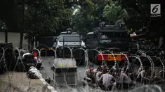 Petugas berjaga dibalik kawat berduri yang dipasang didepan Kedutaan Besar Myanmar, Jakarta, Rabu (6/9).  Jelang aksi yang rencananya akan dihadiri puluhan ribu orang, pihak kepolisian berjaga di sekitar Kedubes Myanmar. (Liputan6.com/Faizal Fanani)