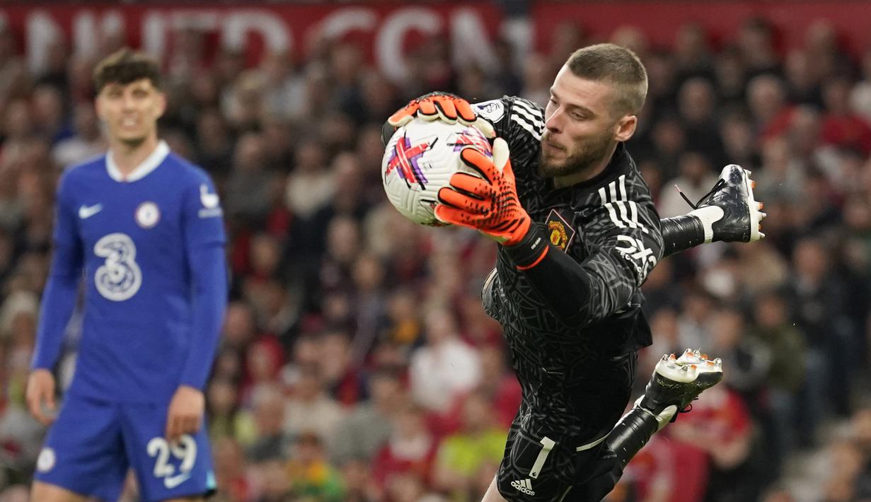 Penjaga gawang Manchester United, David De Gea, berhasil menangkap bola dari tendangan pemain Chelsea dalam pertandingan partai tunda pekan ke-32 English Premier League 2022/2023 yang berlangsung di Old Trafford, Jumat (26/5/2023) dini hari WIB. (AP Photo/Dave Thompson)