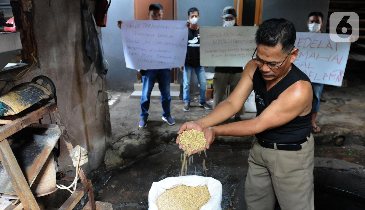 Perajin menunjukkan kedelai saat aksi mogok produksi di Sentra Produksi Tempe Kelurahan Tugu, Cimanggis, Depok, Senin (21/02/2022).  Harga kedelai impor yang mencapai Rp1,1 juta/kwintal membuat ratusan perajin tahu-tempe di Jabodetabek mogok produksi tiga hari ke depan. (merdeka.com/Arie Basuki)