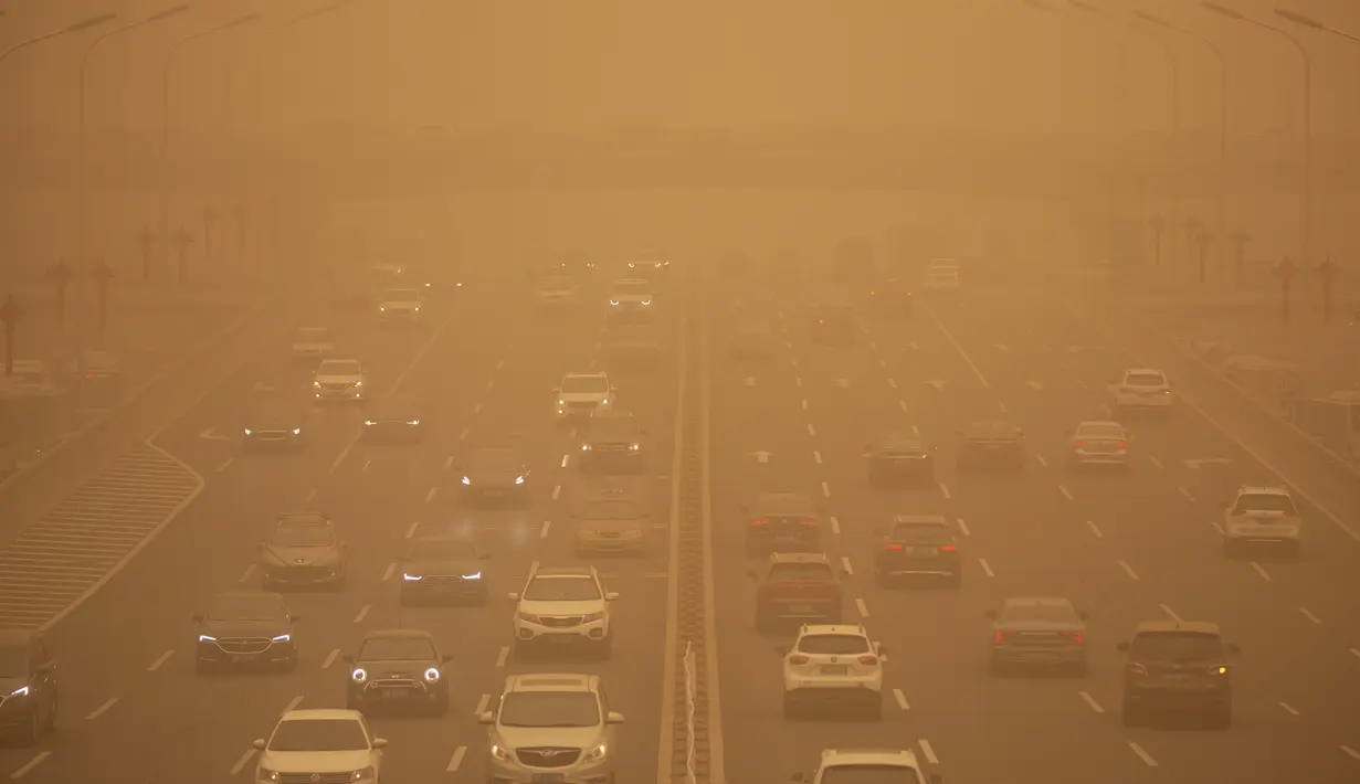 Mobil melintas tol di tengah badai pasir pada jam sibuk pagi hari di Beijing, Senin (15/3/2021). Badan Meteorologi China mengumumkan status kuning dengan menyatakan, badai pasir telah menyebar dari Mongolia ke Provinsi Gansu, Shanxi, dan Hebei, di sekitar Beijing. (AP Photo/Mark Schiefelbein)