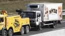 Sebuah truk yang berisi sekitar 50 imigran gelap yang tewas siap diderek dari jalan tol di Austria, dekat perbatasan Hongaria, Kamis (27/8/2015). Indikasi awal mereka tewas karena kekurangan oksigen. (AFP PHOTO/Dieter NAGL)