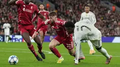 Pemain Liverpool, Conor Bradley (kiri) berebut bola dengan pemain Real Madrid, Vinicius Jr dalam laga Liga Champions 2025/2026 di Anfield, Liverpool, Inggris, Selasa (04/11/2025) waktu setempat. (AP Photo/Jon Super)