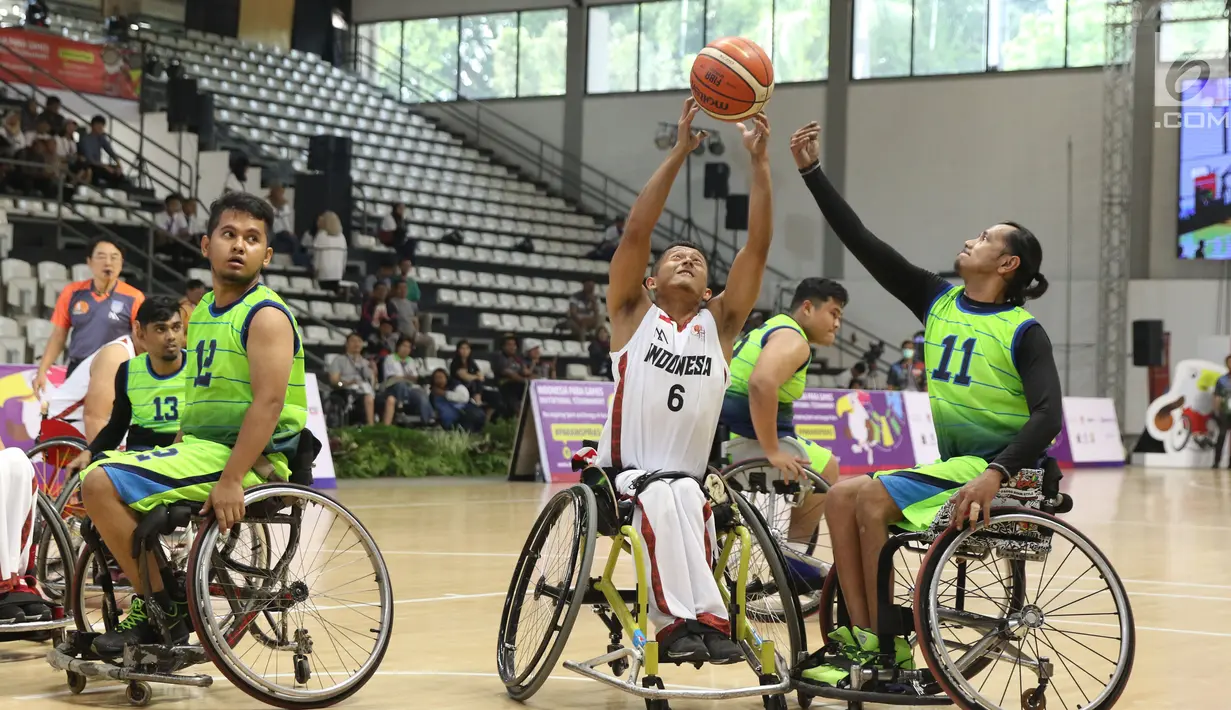 Pebasket difable Indonesia, Danu Kuswantoro (tengah) berebut bola dengan Fazlan Ismail (Malaysia) pada Indonesia Para Games Invitational Tournament 2018 di Hall A Senayan, Jakarta, Minggu (1/7). Indonesia unggul 54-53. (Liputan6.com/Helmi Fithriansyah)