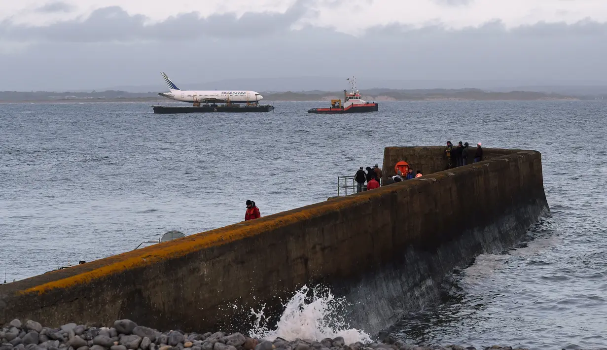 Pesawat Boeing 767 tiba di muara Enniscrone, pantai barat Irlandia, Sabtu (7/5). Tongkang yang memuat pesawat itu ditarik oleh kapal tugboat melalui perairan Atlantik dan memakan waktu selama 36 jam sebelum tiba di tujuan akhir (REUTERS/Clodagh Kilcoyne)