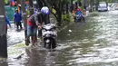 Pengendara mendorong motor yang mogok melintasi banjir di kawasan Duta, Jelambar, Jakarta Barat, Selasa (5/3). Hujan yang mengguyur Jakarta dan sekitarnya sejak dini hari tadi membuat beberapa kawasan terendam banjir. (merdeka.com/Arie Basuki)