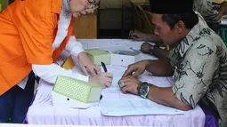 Terdakwa kasus penyebaran berita bohong atau hoaks, Ratna Sarumpaet mengisi daftar hadir di TPS 15 rutan Polda Metro Jaya, Rabu (17/4). Ratna Sarumpaet tiba mengenakan baju tahanan berwarna oranya bersama 538 tahanan menggunakan hak suaranya pada Pemilu 2019. (Liputan6.com/Herman Zakharia)
