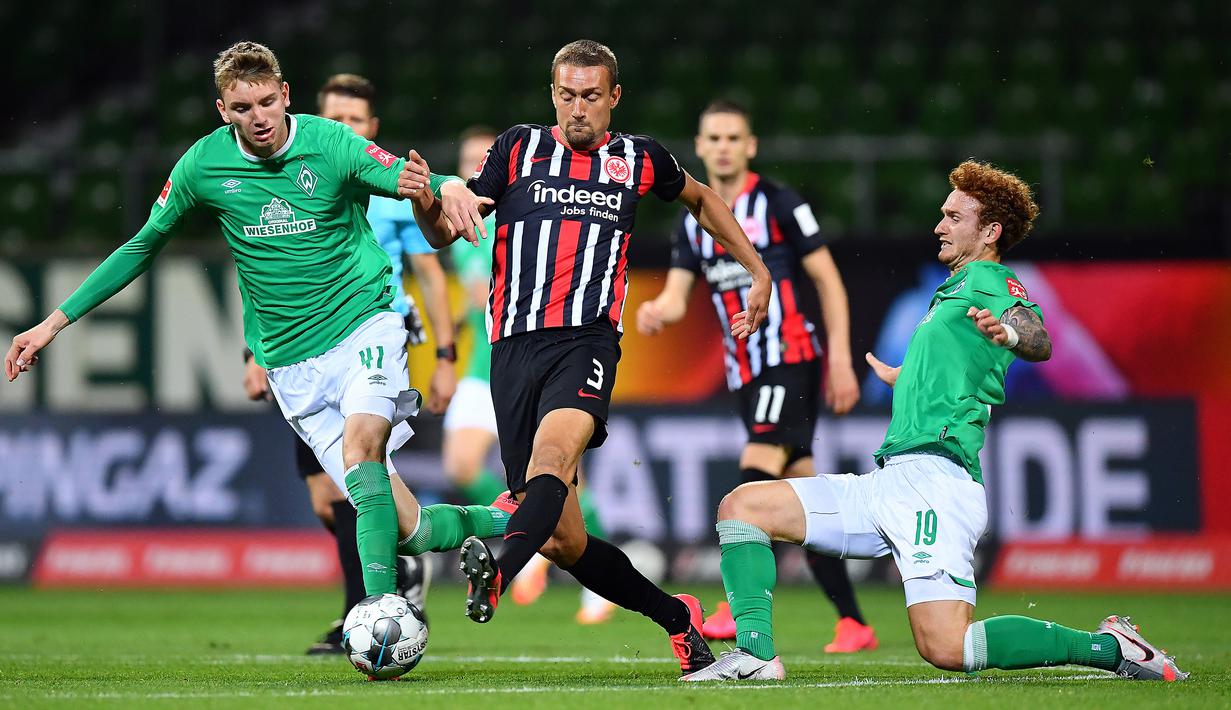 Gelandang Eintracht Frankfurt, Stefan Ilsanker, berebut bola dengan pemain Werder Bremen pada laga lanjutan Bundesliga di Weser Stadion, Kamis (4/6/2020) dini hari WIB. Frankfurt menang 3-0 atas Bremen. (AFP/Stuart Franklin/pool)