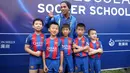 Ronaldinho berfoto bersama dengan sejumlah pemain sepak bola cilik saat peluncuran akademi sepak bola di China (24/2). Dalam peresmian akademi sepak bola tersebut Ronaldinho ditunjuk sebagai salah satu duta dari Barcelona. (Handout / Mission Hills / AFP)
