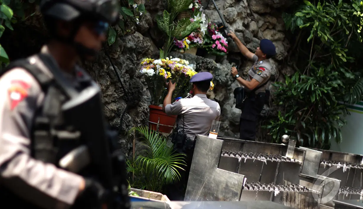 Personel Gegana Polda Metro Jaya  melakukan penyisiran di setiap sudut area Gereja Katedral, Jakarta, Rabu (24/12/2014). (Liputan6.com/Faizal Fanani)