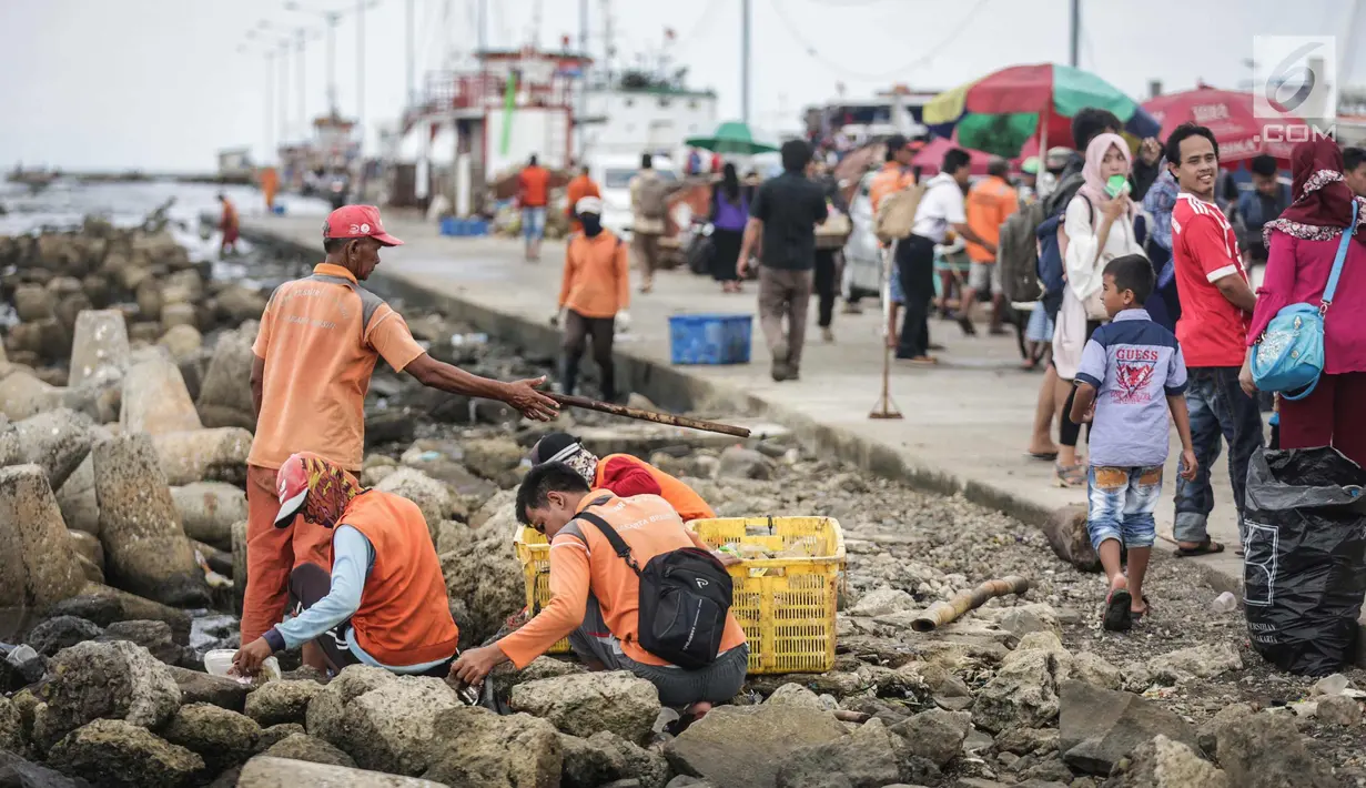 Petugas kebersihan membersihkan sampah laut di Pelabuhan Kali Adem, Jakarta, Senin (1/1). Banyaknya sampah plastik dibandingkan ikan yang gagal dikelola dengan baik membuat limbah yang mengakibatkan laut tercemar.  (Liputan6.com/Faizal Fanani)
