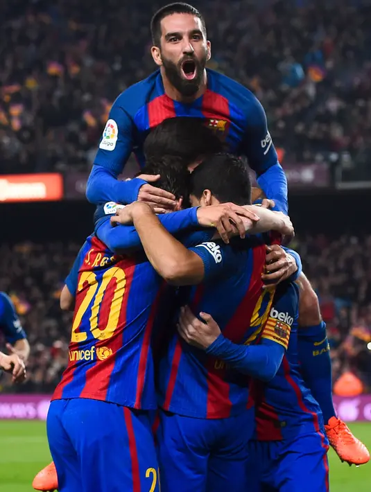 Pemain Barcelona merayakan gol pembuka ke gawang Atletico Madrid pada leg kedua semifinal Copa del Rey di Estadio Camp Nou, Selasa (7/2). Di leg kedua semifinal yang diwarnai tiga kartu merah, Blaugrana bermain imbang 1-1 dengan Atletico. (Josep Lago/AFP)