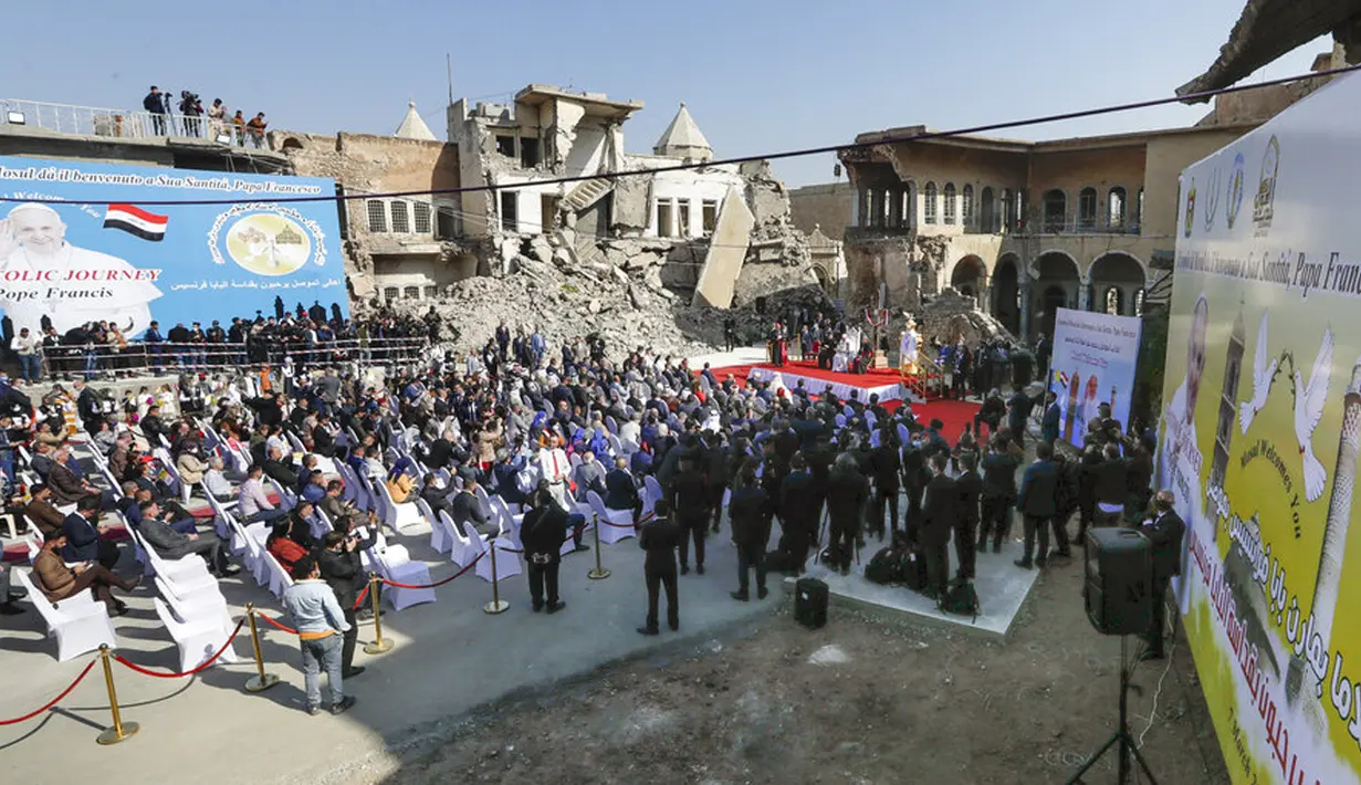 Paus Fransiskus, dikelilingi oleh puing-puing gereja yang hancur, memimpin doa bagi para korban perang di Lapangan Gereja Hosh al-Bieaa, Mosul, Irak, yang pernah menjadi ibu kota de-facto ISIS, Minggu (7/3/2021). (AP Photo/Andrew Medichini)