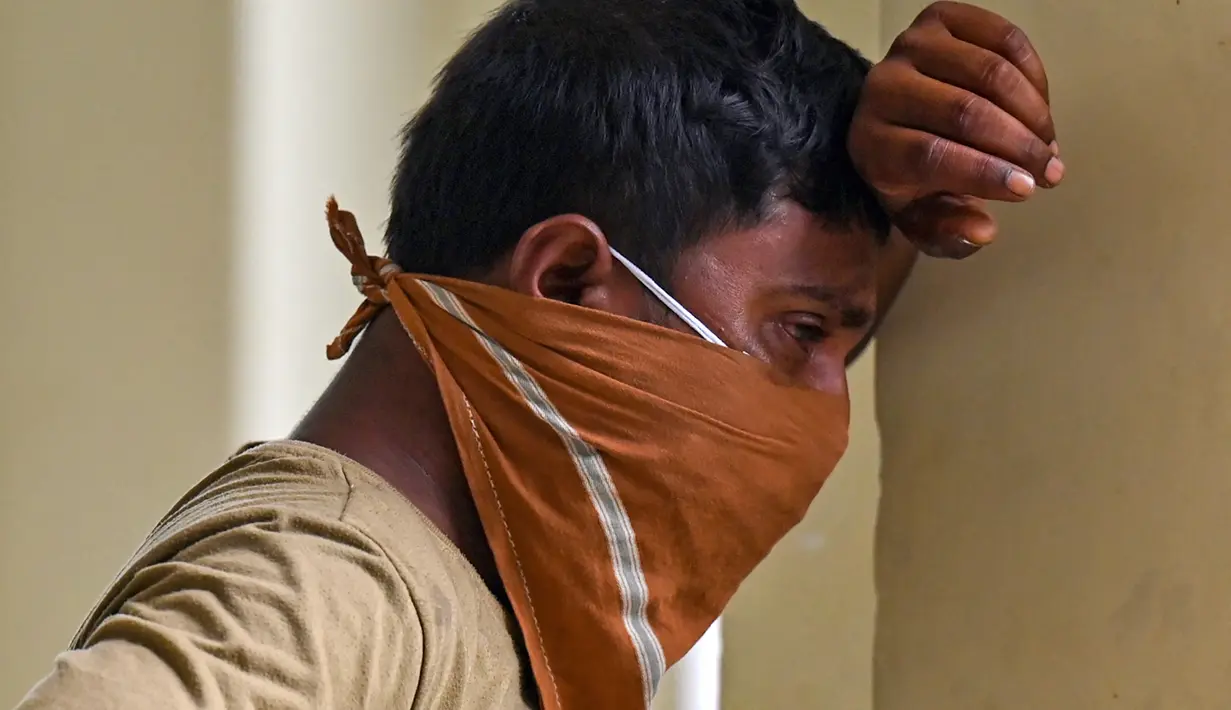 Seorang anggota keluarga korban menangis di taman bisnis yang digunakan sebagai kamar mayat sementara untuk mengidentifikasi jenazah yang ditemukan dari reruntuhan gerbong tabrakan tiga kereta di dekat Balasore, di negara bagian Odisha, India, pada 4 Juni 2023. (Photo by Punit PARANJPE / AFP)