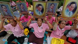 Warga berkumpul di Rumah Sakit Siriraj sambil membawa gambar Raja Thailand Bhumibol Adulyadej di Bangkok, Thailand, Kamis (13/10). Bhumibol meninggal dunia pada usia 88 tahun, setelah sakit dalam beberapa tahun terakhir. (REUTERS / Chaiwat Subprasom)
