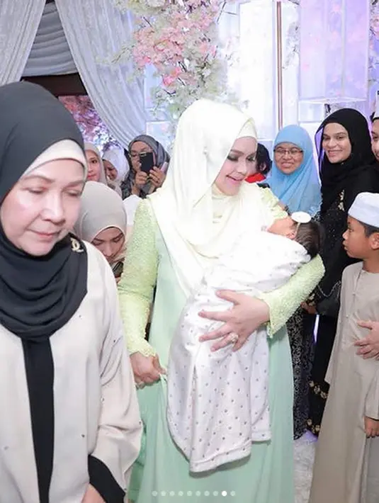Sebagai ibu, Siti pastinya sangat berbahagia dengan kelahiran anak pertamanya ini. Terlihat senyuman semringah di wajah Siti saat menggendong bayinya di acara akikah. (Instagram/ctdk)