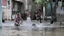 Anak- anak bermain saat banjir menggenangi kawasan Rawa Terate, Cakung Jakarta, Rabu (30/1). Banjir yang mencapai ketinggian pinggang orang dewasa terjadi sejak dini hari. (merdeka.com/Iqbal S. Nugroho)