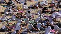 Peserta melakukan gerakan yoga selama latihan di gurun Samalayuca, negara bagian Chihuahua, Meksiko, 28 April 2018. Latihan di atas pasir gurun yang terik ini menjadi tantangan tersendiri bagi para pencinta Yoga. (AFP PHOTO / HERIKA MARTINEZ)