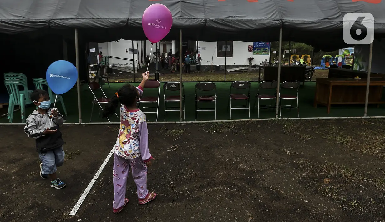 Anak-anak pengungsi Gunung Merapi bermain balon di Barak Pengungsian Glagaharjo, Cangkringan, Sleman, Yogyakarta, Jumat (20/11/2020). Fasilitas bermain ini sebagai salah satu upaya untuk menjaga kesehatan mental anak-anak pengungsi Gunung Merapi. (Liputan6.com/Johan Tallo)