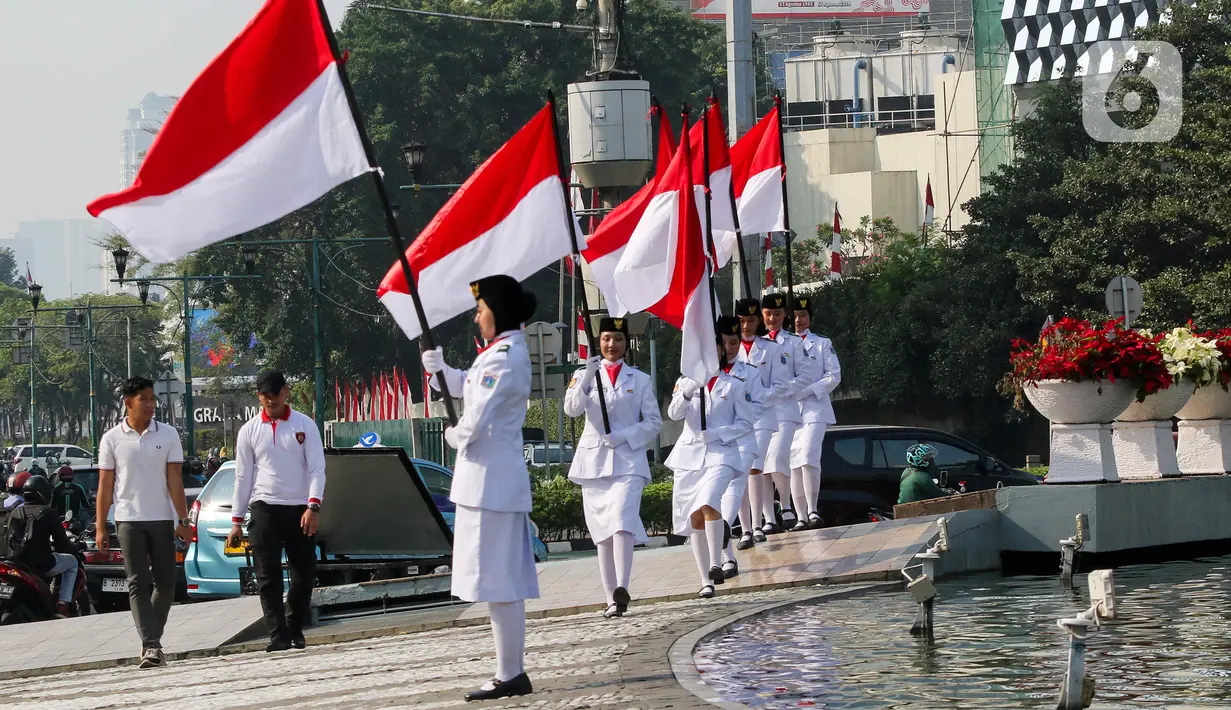 Sejumlah pasukan pengibar bendera (Paskibra) berbaris membawa bendera Merah Putih di Bundaran Hotel Indonesia (HI), Jakarta, Kamis (15/8/2024). (Liputan6.com/Herman Zakharia)
