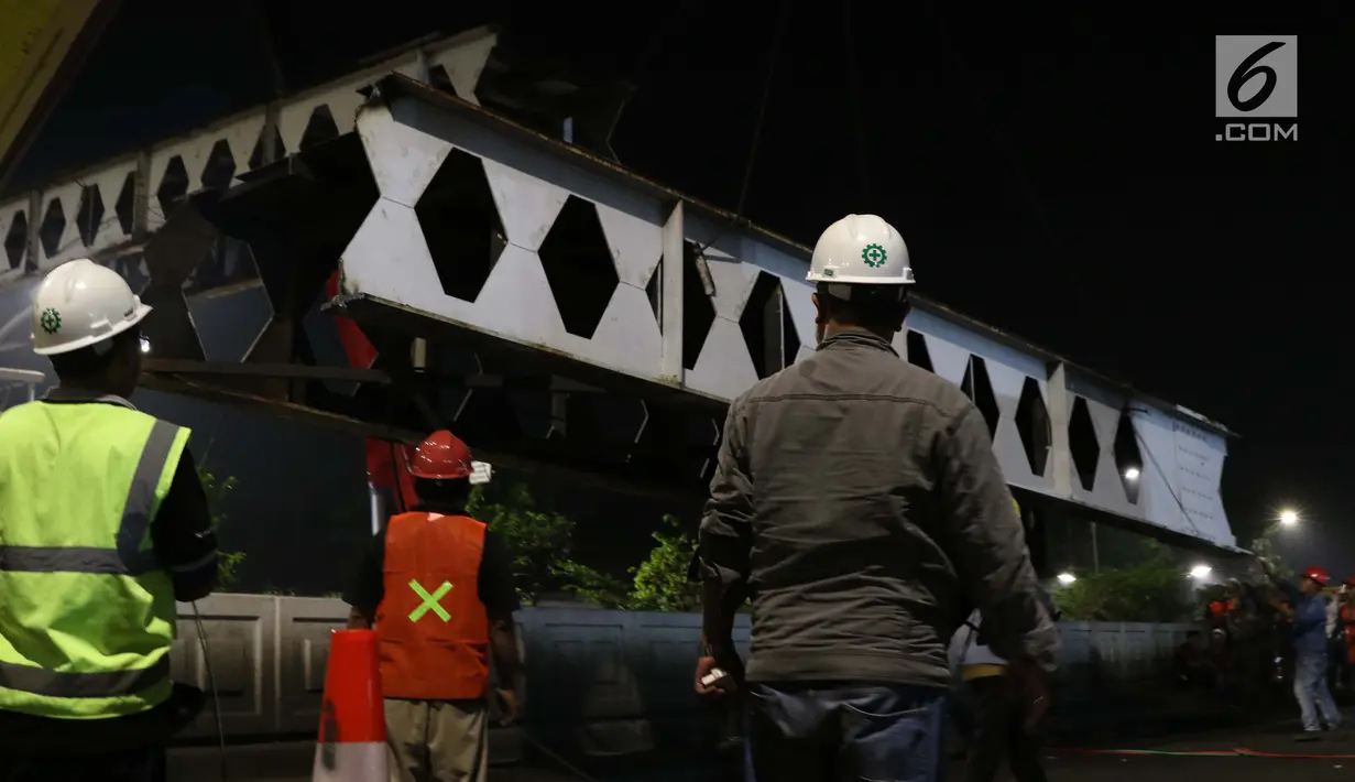 Pekerja melakukan proses penurunan rangka utama Jembatan Penyeberangan Orang Pasar Minggu, Jakarta, Sabtu (6/4). JPO Pasar Minggu akan dibangun kembali dengan konsep lebih futuristik serta ramah disabilitas. (Liputan6.com/Helmi Fithriansyah)