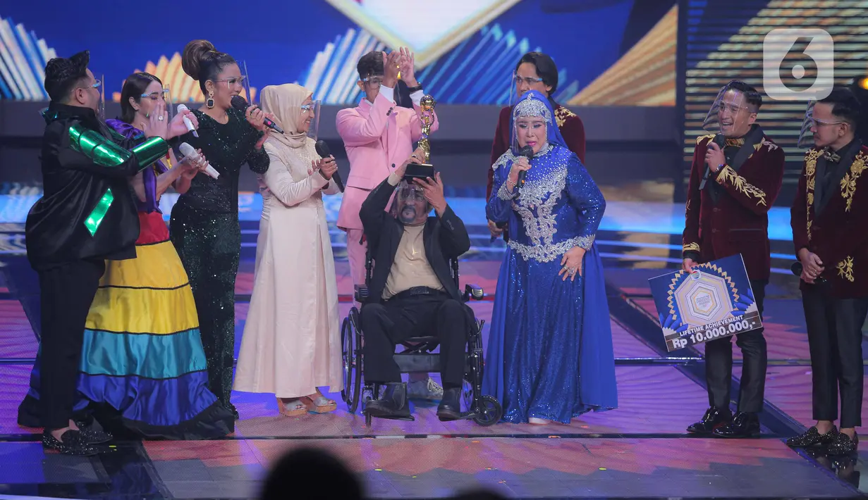 Penyanyi dangdut senior Hamdan ATT mendapatkan penghargaan Lifetime Achievement dalam acara Indonesian Dangdut Awards 2021 di Studio 5 Indosiar, Jakarta, Rabu (1/12/2021). Penghargaan diberikan atas dedikasi Hamdan ATT untuk musik dangdut di tanah air. (Liputan6.com/Faizal Fanani)