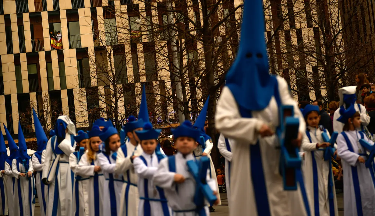 Peniten bertopeng menyusuri jalan dalam prosesi Minggu Palma di Zaragoza, Spanyol, Minggu (25/3). Minggu Palma dirayakan menjelang Paskah. (Foto AP/Alvaro Barrientos)