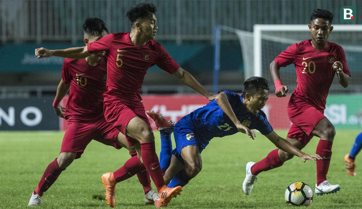 Bek Timnas Indonesia, Samuel Simanjuntak, menjatuhkan striker Thailand, Yuthapichai Lertlum, pada laga PSSI 88th U-19 di Stadion Pakansari, Jawa Barat, Minggu (23/9/2018). Kedua negara bermain imbang 2-2. (Bola.com/Vitalis Yogi Trisna)