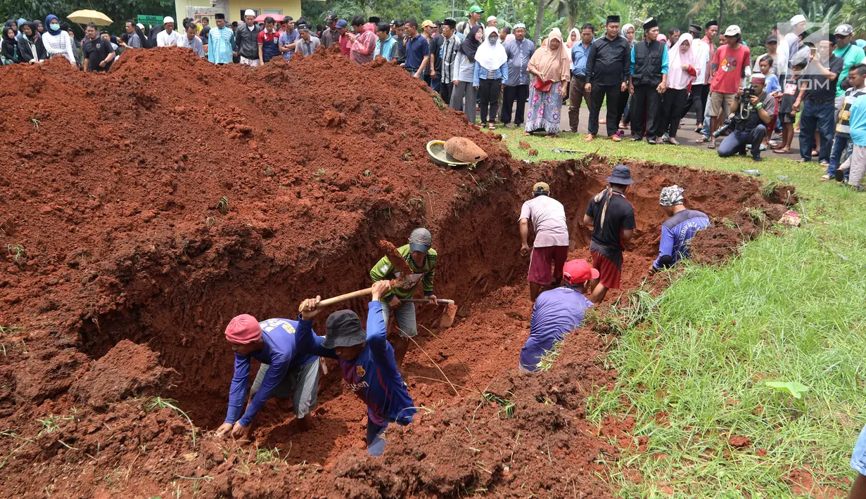 Proses penggalian jelang pemakaman korban kecelakaan Tanjakan Emen di Tempat Pemakaman Umum (TPU) Legoso, Tangerang Selatan, Banten, Minggu (11/2). Korban tewas merupakan rombongan Koperasi Permata Ciputat. (Liputan6.com/JohanTallo)