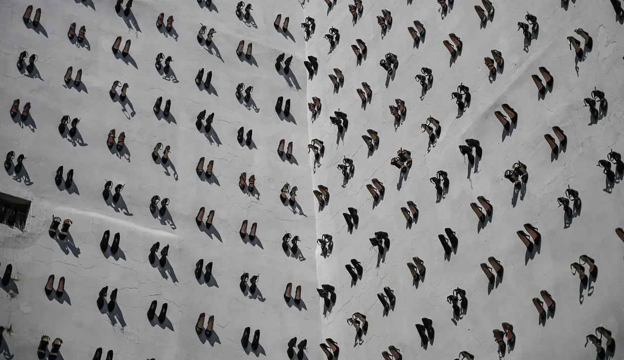 Pameran seni kontemporer yang meletakkan 440 sepatu perempuan di dinding sebuah bangunan di Istanbul, Selasa (17/9/2019). Sepatu-sepatu itu melambangkan perempuan yang dibunuh oleh pasangan dan suami mereka di Turki sepanjang tahun 2018. (Ozan KOSE/AFP)