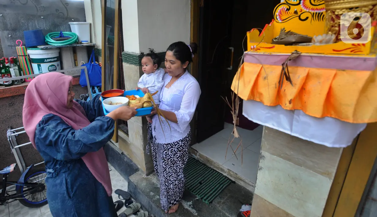 Umat Muslim mengantarkan makanan ketupat di kawasan Perumahan Pondok Kampial Permai, Nusa Dua, Bali, Jumat (21/04/2023). Momen Idul Fitri dimanfaatkan warga untuk saling tolong menolong sebagai semangat toleransi beragama. (merdeka.com/Arie Basuki)