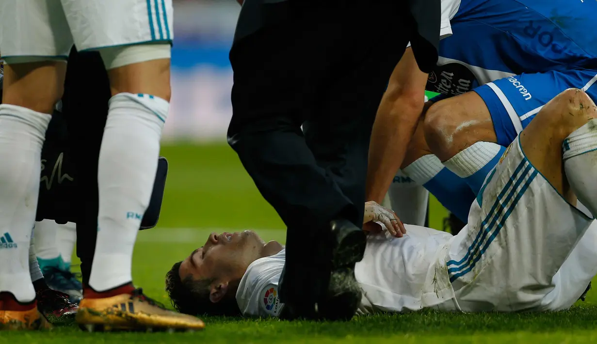 Cristiano Ronaldo tergeletak di lapangan setelah bek Deportivo de la Coruna, Fabian Schaer menendang kepalanya saat bertanding di La Liga Spanyol di Santiago Bernabeu, Madrid (21/1). Madrid menang 7-1 di pertandingan tersebut. (AP Photo/Francisco Seco)
