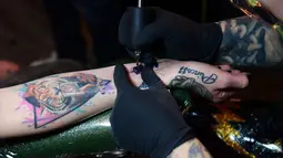 Seniman Tiffany Garcia membuat tato gelombang suara pada lengan Hanna Washlake di Black Raven Tattoo California, 12 April 2018. Lewat aplikasi Skin Motion di ponsel, tato akan terbaca dan mengeluarkan suara sesuai kode pada tato. (AFP/FREDERIC J. BROWN)