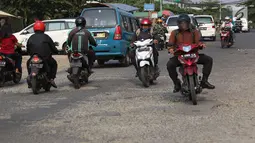 Lalu lalang kendaraan saat jalan berlubang di kawasan Gas Alam, Depok, Jawa Barat, Kamis (4/10). Hingga kini kondisi jalan rusak di kawasan tersebut tidak diperbaiki oleh pihak terkait. (Liputan6.com/Immanuel Antonius)