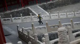 Seorang wanita berjalan saat melakukan tur ke Kota Terlarang di Beijing, (7/3). Kota Terlarang, merupakan istana terisolasi kaisar Qing dan Dinasti Ming China untuk tempat wisata utama yang terletak di pusat ibu kota. (AP Photo/Aijaz Rahi)